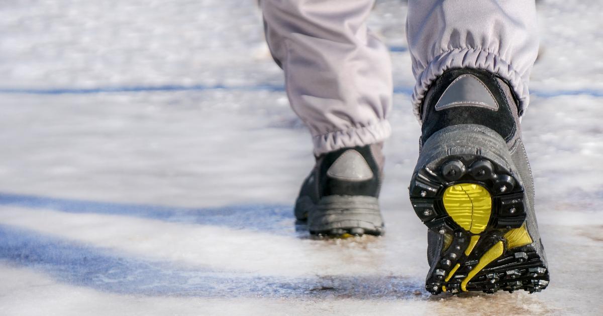 person walking on slippery sidewalk with non skid boots