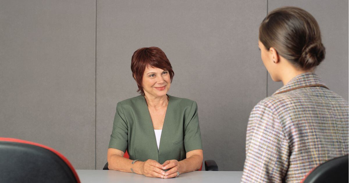 Employer and recruiter discussing administrative hiring needs in a face-to-face meeting