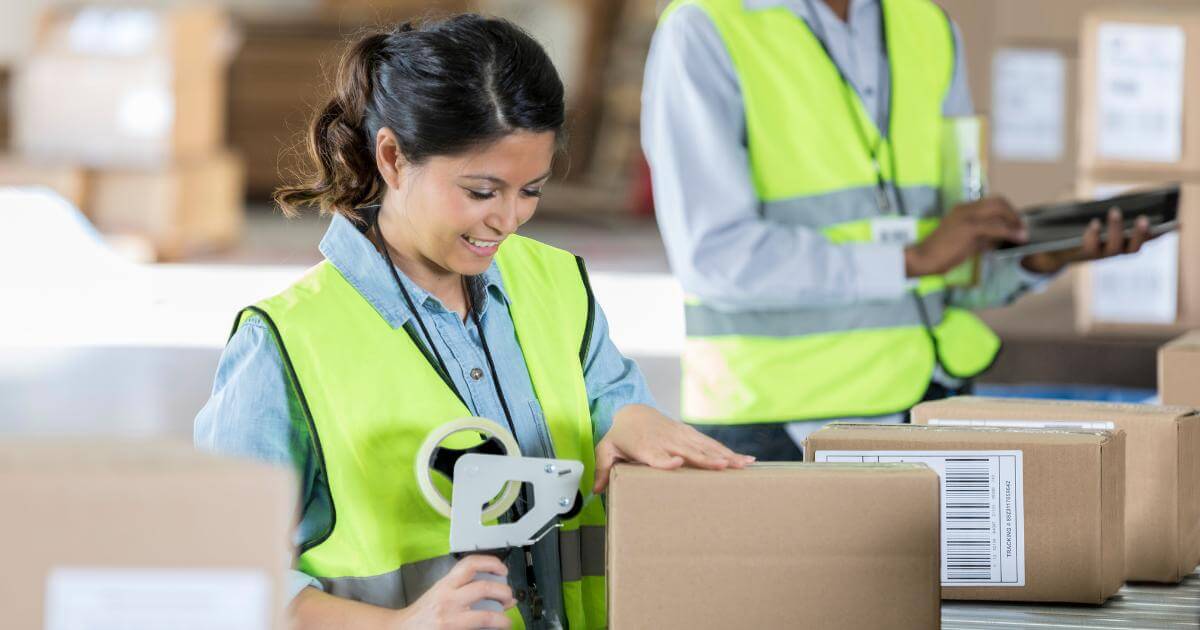 female warehouse worker taping box